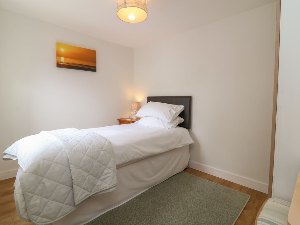 A bedroom with a bed and lamp at Dingle Dell in Braunton