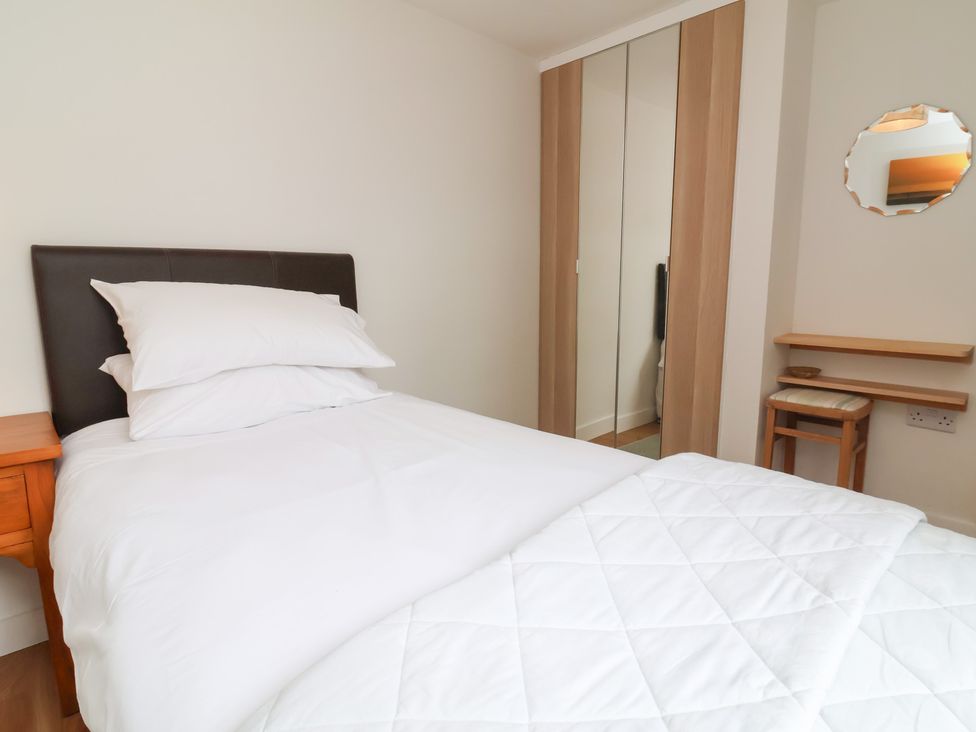 A bedroom with a bed and wardrobe at Dingle Dell in Braunton