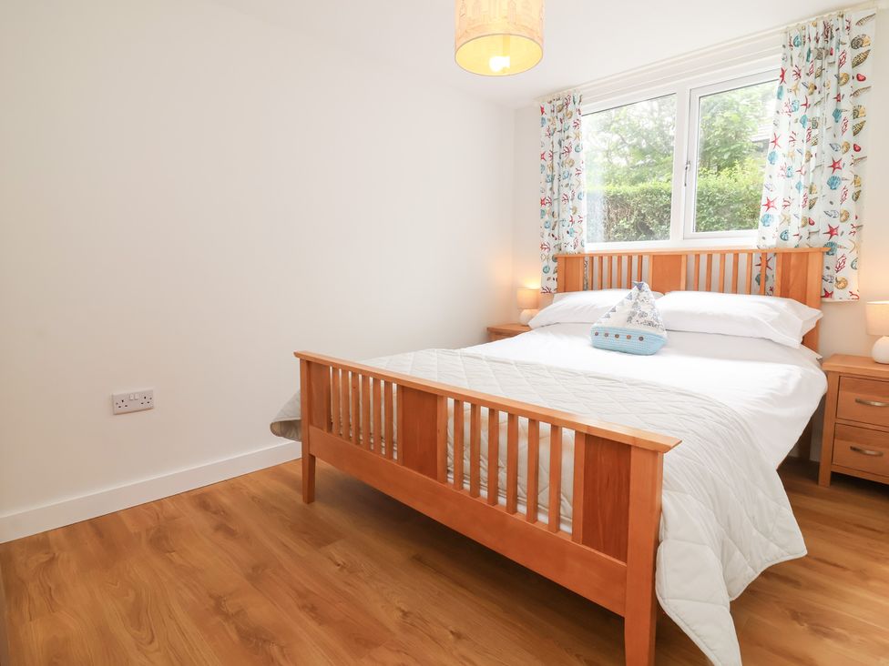 A bedroom with a bed and nightstand at Dingle Dell in Braunton