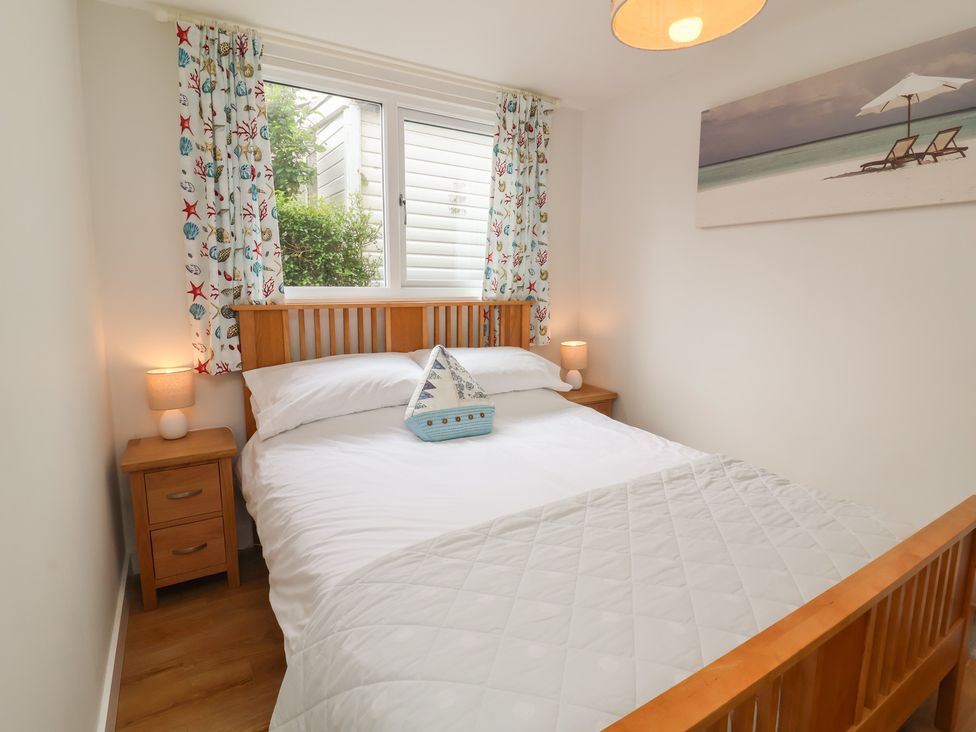 A bedroom with a bed and bedside tables at Dingle Dell in Braunton