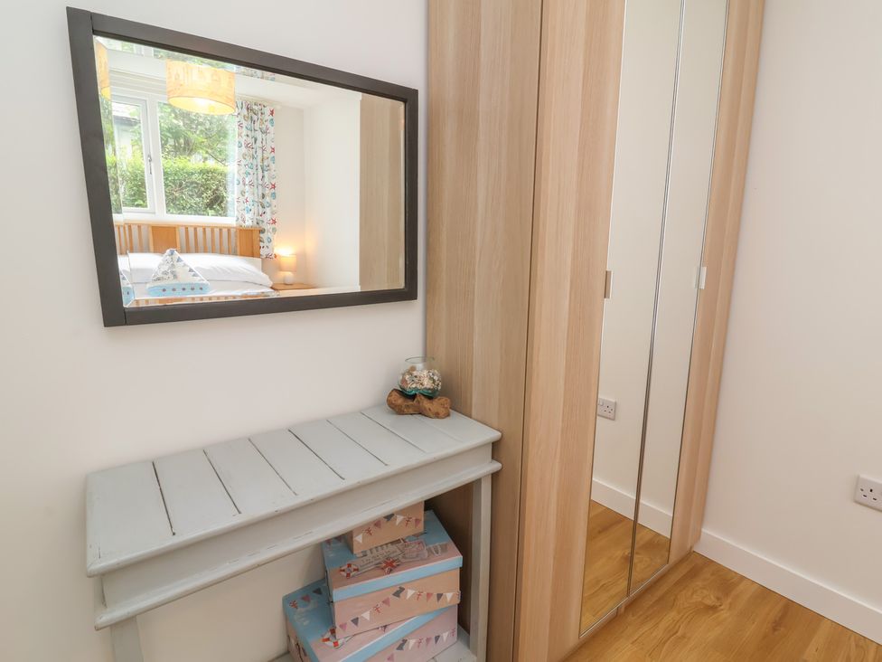 A bedroom with a mirror and a bed at Dingle Dell in Braunton