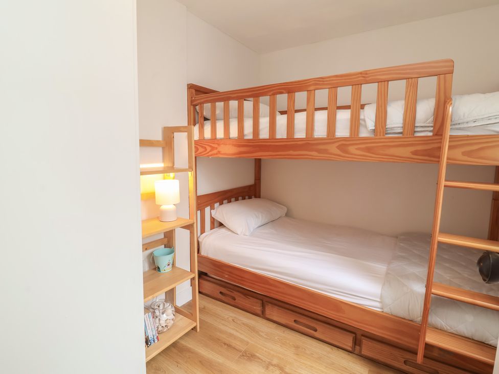 A bedroom with a bunk bed and a single bed at Dingle Dell in Braunton