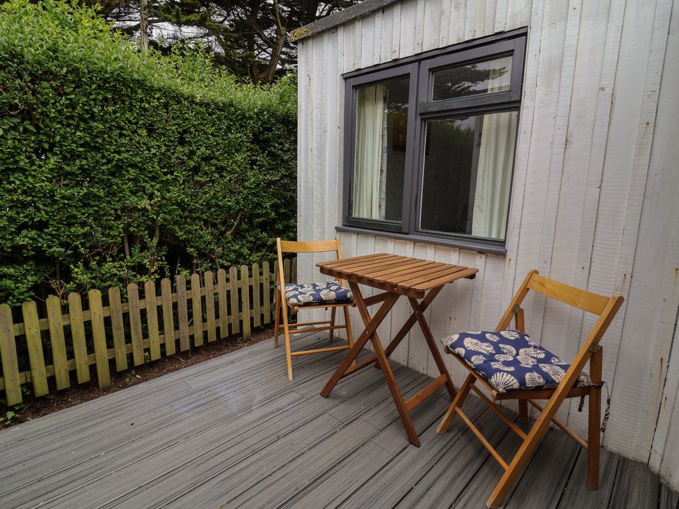 A patio with two chairs and a table at Dingle Dell in Braunton