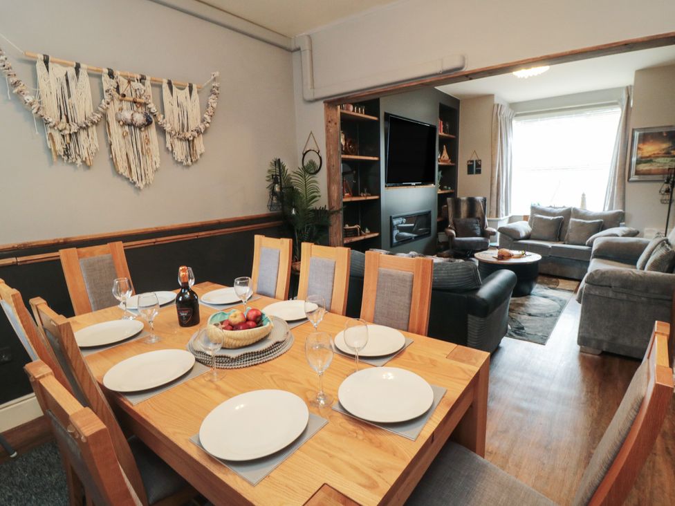 A dining room with a table set for dinner and sofas in the background at Memory Maker in Bridlington