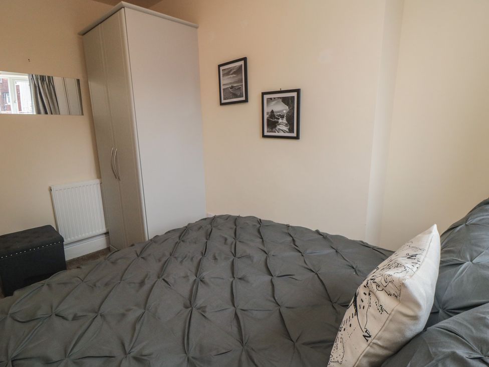 A bedroom with a bed, wardrobe, and pictures at Memory Maker in Bridlington