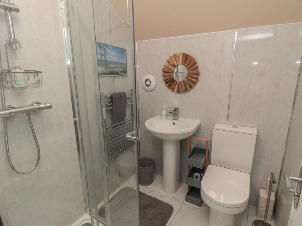 A bathroom with a shower, toilet, sink and storage unit at Memory Maker, Bridlington