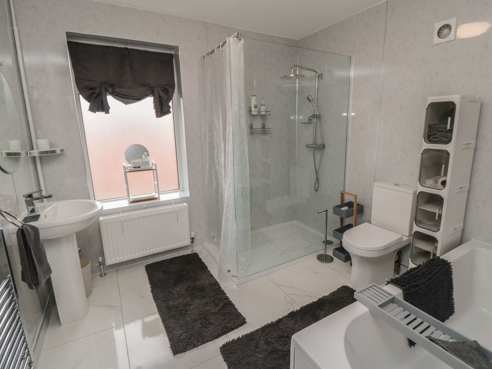 A bathroom with a shower, bathtub, and sink at Memory Maker in Bridlington
