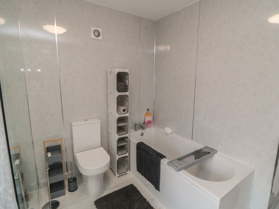 A bathroom with a bathtub and toilet at Memory Maker in Bridlington