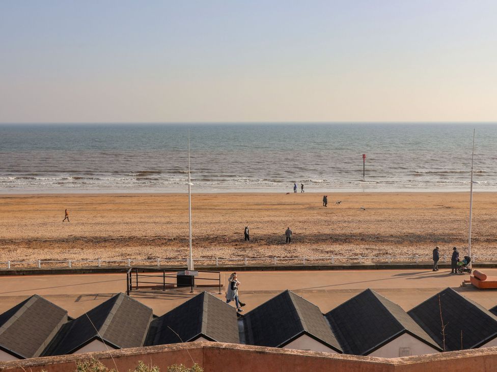 A beach scene with huts and people on the sand at Memory Maker in Bridlington