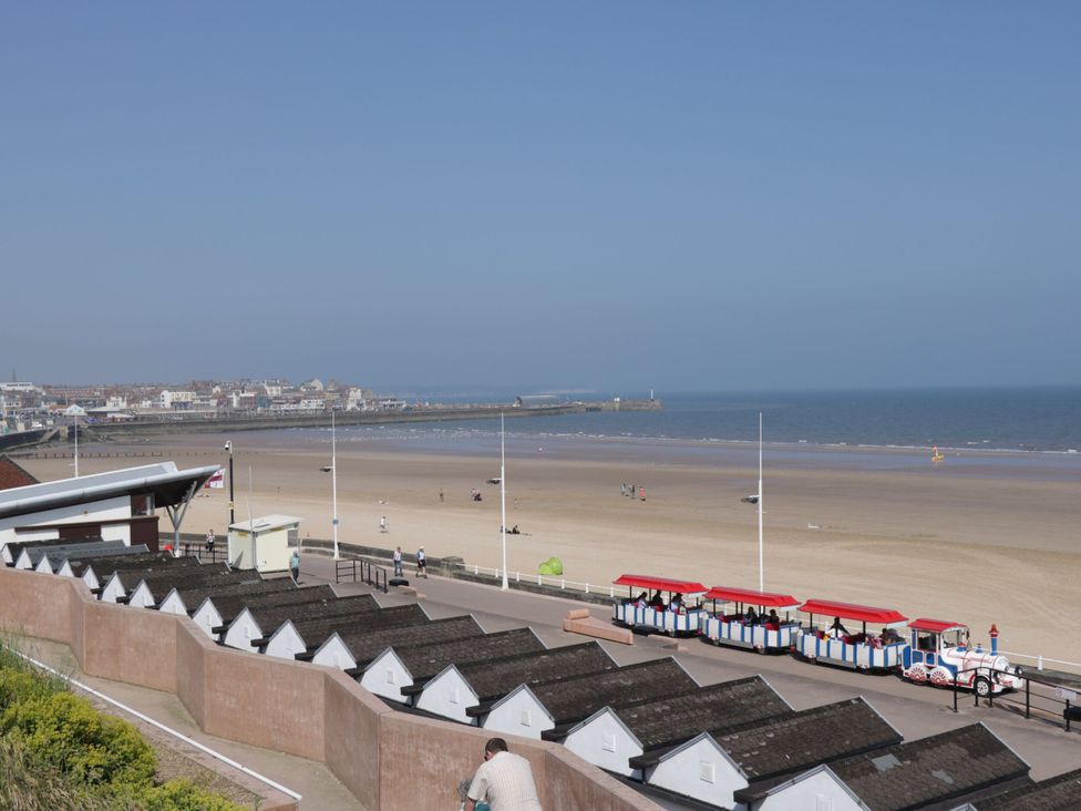 A view of beach huts and ocean along the promenade at Memory Maker in Bridlington