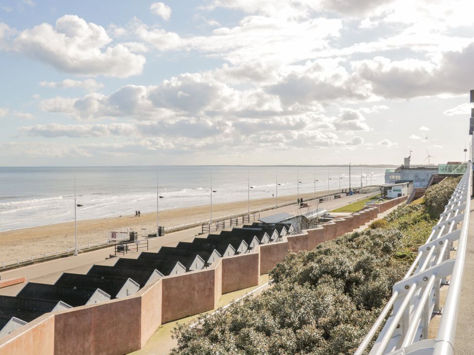 A beach with huts and a walkway at Memory Maker in Bridlington