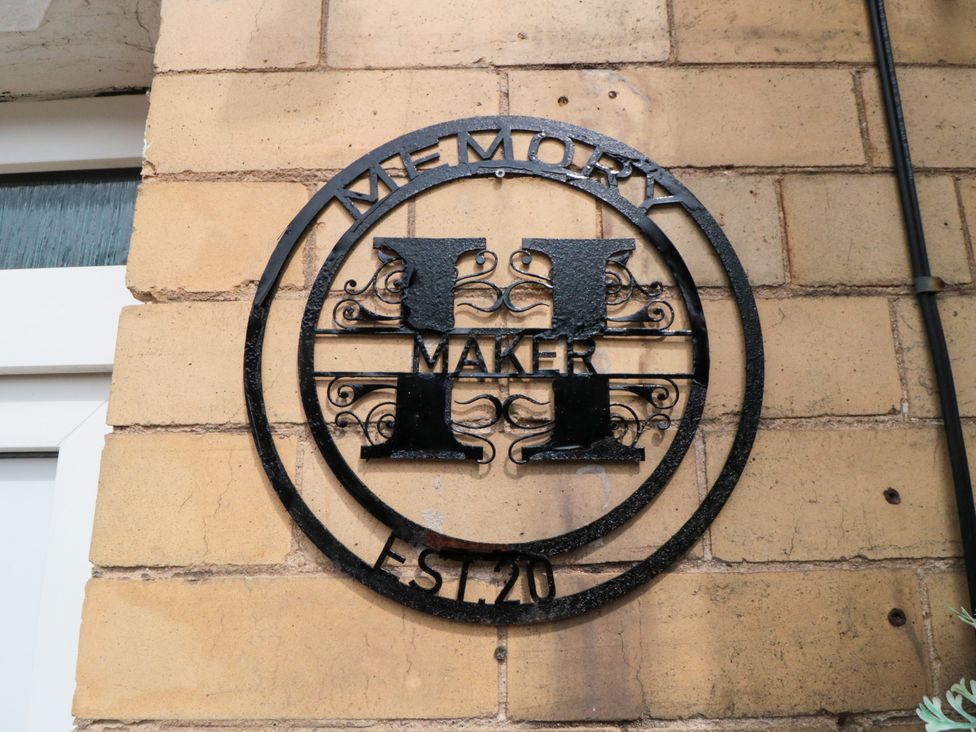 A decorative sign attached to a brick wall at Memory Maker in Bridlington