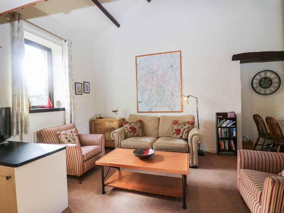 A living room with a sofa coffee table and wall map at Rooftops in Lindale