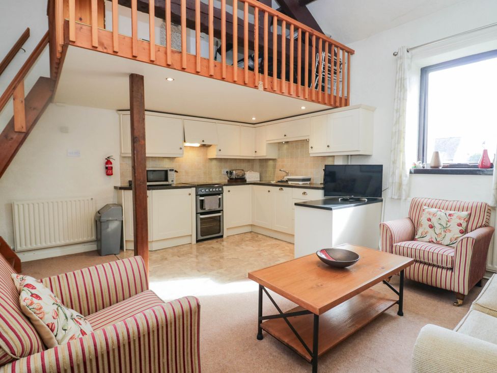 A living room with a kitchen area and seating at Rooftops in Lindale