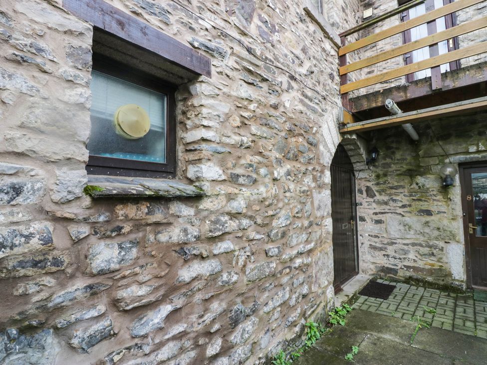 An exterior view showing a stone wall with a window and door at Rooftops in Lindale