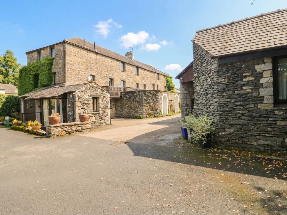 A stone building with a pathway and flower pots at Rooftops in Lindale