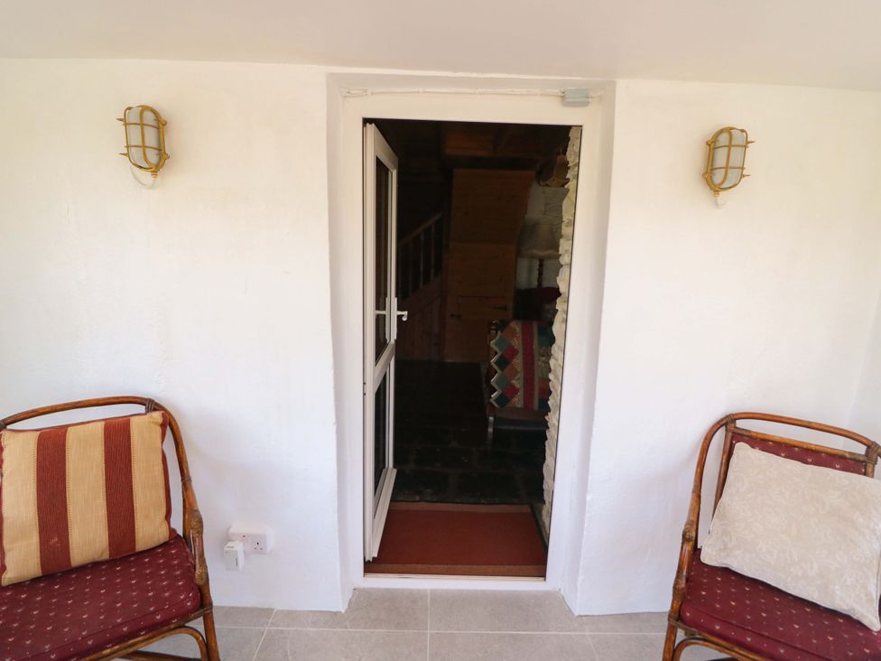 A doorway leading to a staircase with chairs at Tach Ferme