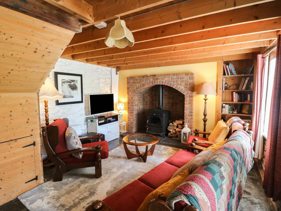 A living room with a fireplace, sofa, and television at Tach Ferme