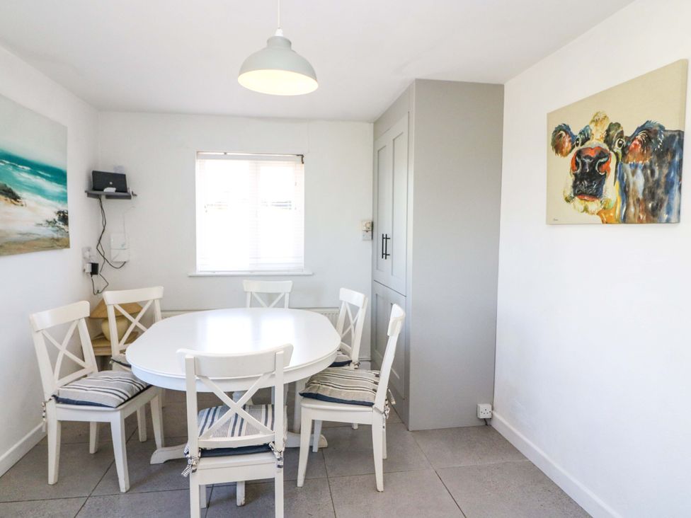 A dining room with a round table and chairs at Tach Ferme