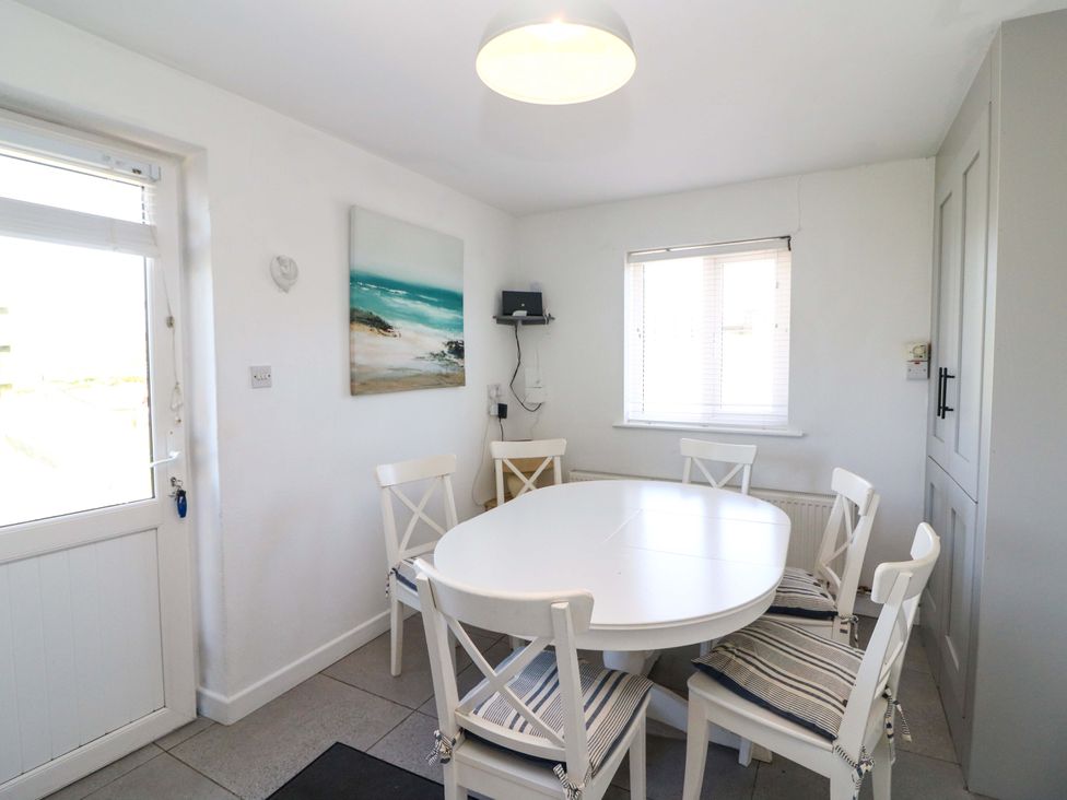 A dining room with a round table and chairs at Tach Ferme