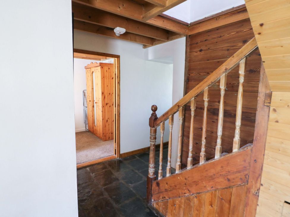 A hallway with stairs and a wardrobe at Tach Ferme
