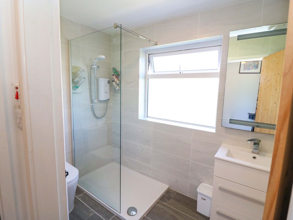 A bathroom with a shower, toilet, and sink at Tach Ferme