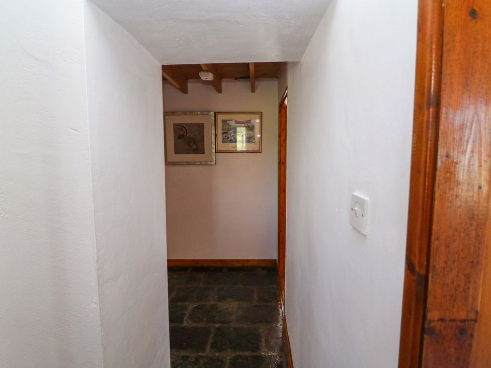 A hallway with framed artwork and stone floor at Tach Ferme