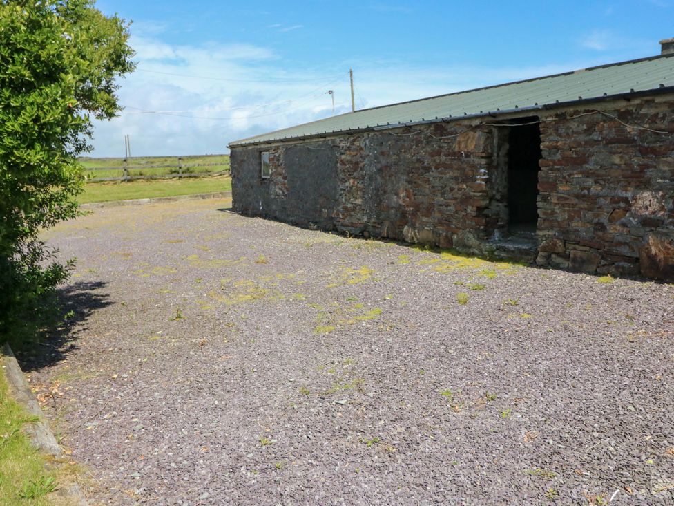 An outdoor area with a stone building and gravel surface at Tach Ferme 