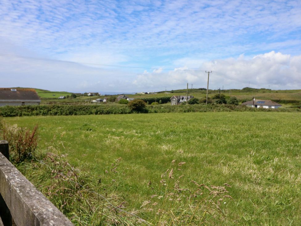 A field with houses and electric poles at Tach Ferme