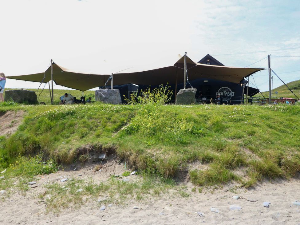 A tent and building on a beach at Tach Ferme