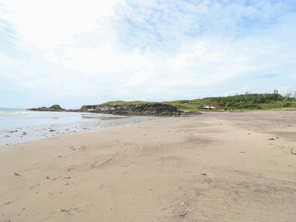 A beach with sand and cliffs near the ocean at Tach Ferme in 