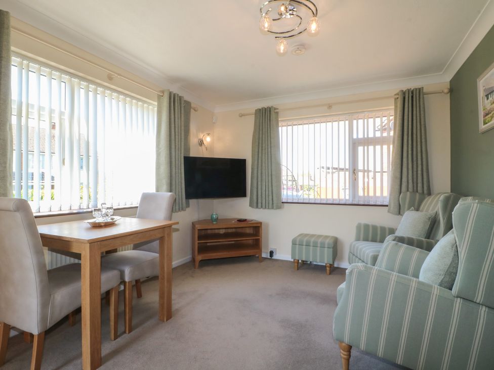 A living room with a dining table and chairs and a television at 27a Wolds Drive Nottingham