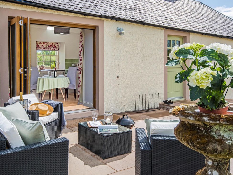An outdoor seating area with a table and plant pot at Country Cottage Sleeps 3 with Garden and Parking