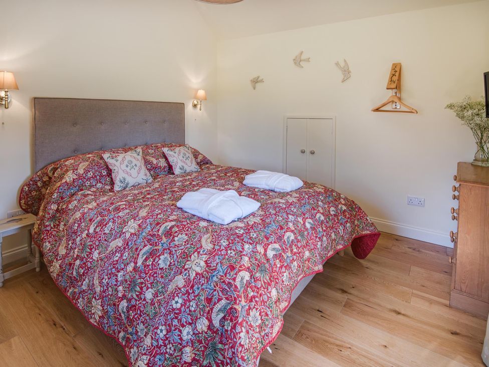 A bedroom with a large bed and bedside lamps at Country Cottage Sleeps 3 with Garden and Parking