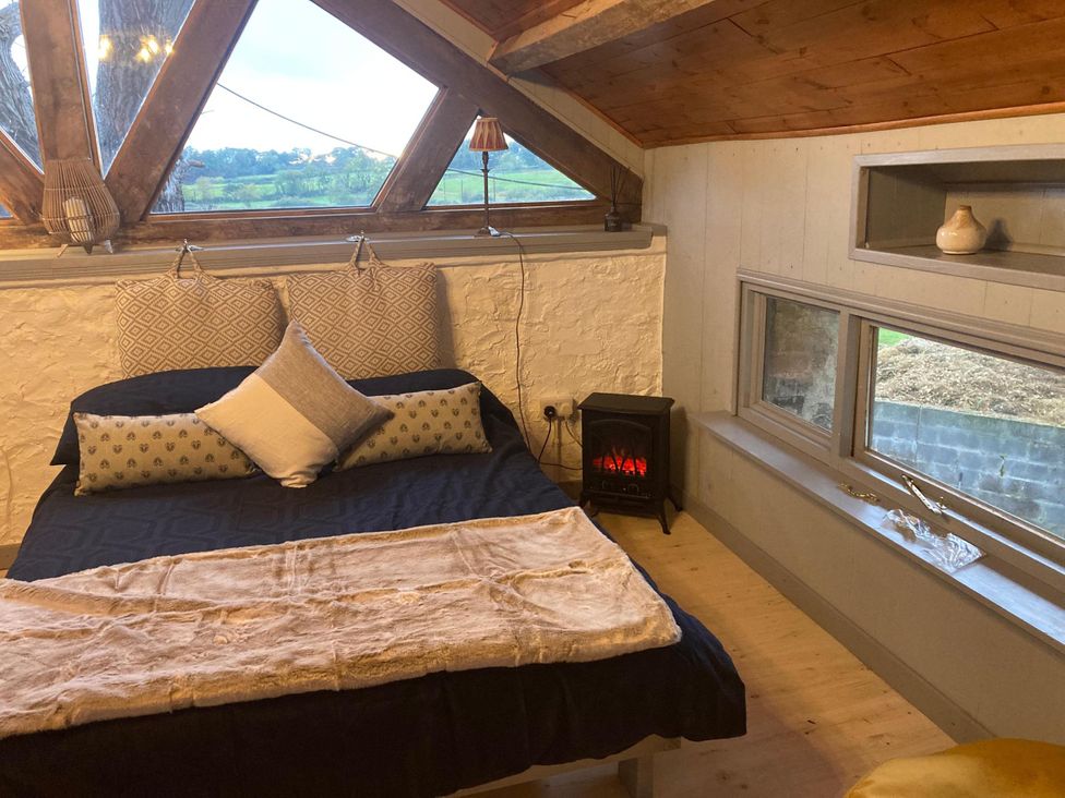 A bedroom with a bed and pillows at 1-Bed Barn Conversion, Sleeps 2 with Parking, Niwbwrch (newborough)