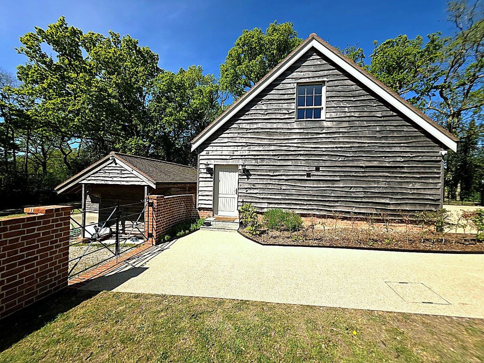 A house with a garage and pathway at Charming Barn Annex with Stables New Forest Escape
