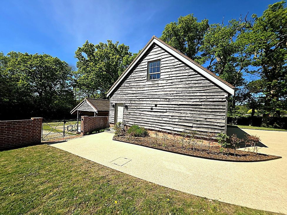 A building with a gate and pathway at Charming Barn Annex with Stables New Forest Escape