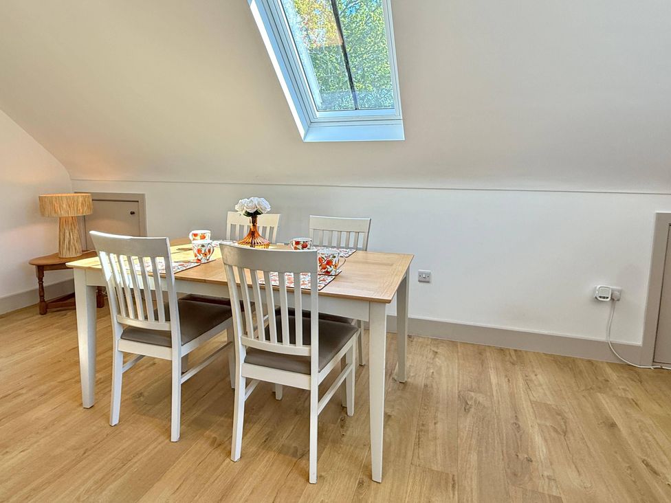 A dining room with a table and chairs at Charming Barn Annex with Stables New Forest Escape