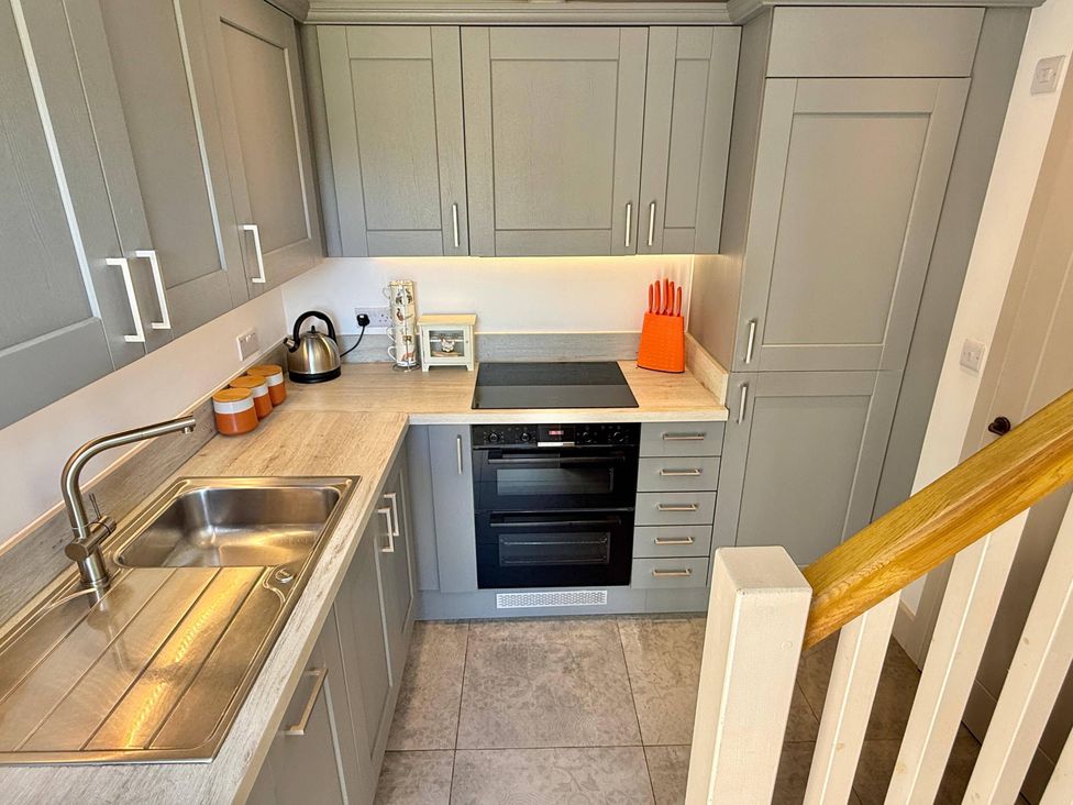 A kitchen with cabinets, sink, stove, and kettle at Charming Barn Annex with Stables New Forest Escape