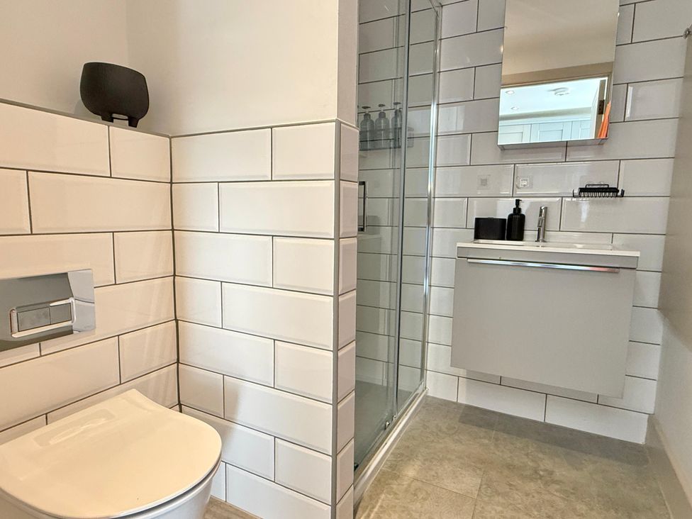A bathroom with a toilet, shower, and sink at Charming Barn Annex with Stables New Forest Escape