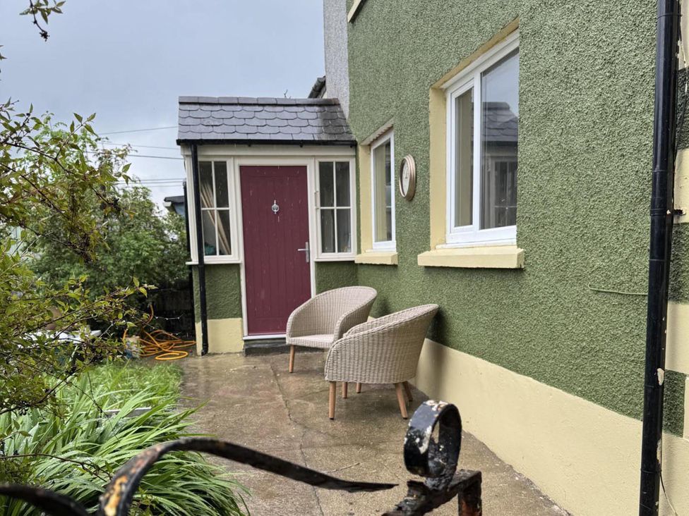 A house exterior with outdoor chairs and a front door at Llysawelon 2-Bed Cottage, Sleeps 5, Pets Ok near Llansteffan