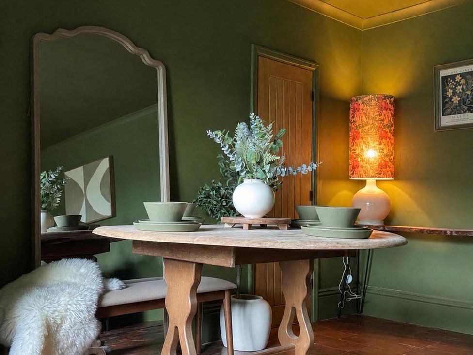 A dining room with a round table and a mirror at Llysawelon 2-Bed Cottage, Sleeps 5, Pets Ok Llysawelon near Llansteffan