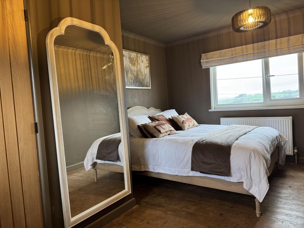 A bedroom with a bed and mirror at Llysawelon 2-Bed Cottage, Sleeps 5, Pets Ok near Llysawelon near Llansteffan