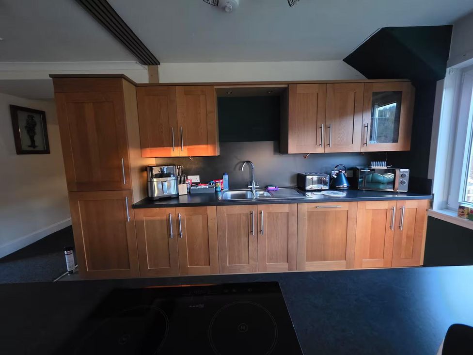 A kitchen with cabinets, sink, kettle, microwave, and toaster at Highlands - River View - Apt - Sleeps 4 - Garden Garve near Strathpeffer