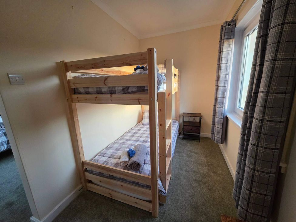 A bunk bed with a nightstand in a bedroom at Highlands - River View - Apt - Sleeps 4 - Garden Garve near Strathpeffer