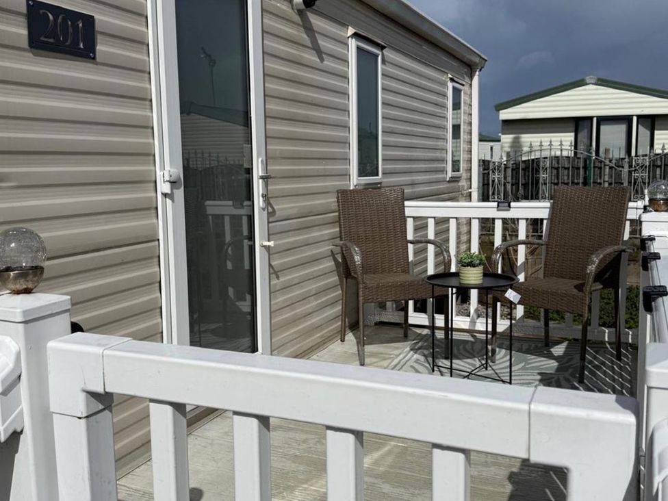 An outdoor patio with two chairs and a table at 2-Bed Caravan, Sleeps 6 w/ Parking, No Pass Needed