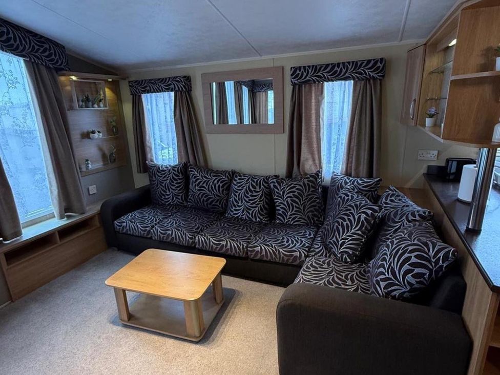A living room with a sofa and coffee table at 2-Bed Caravan, Sleeps 6 w/ Parking, No Pass Needed