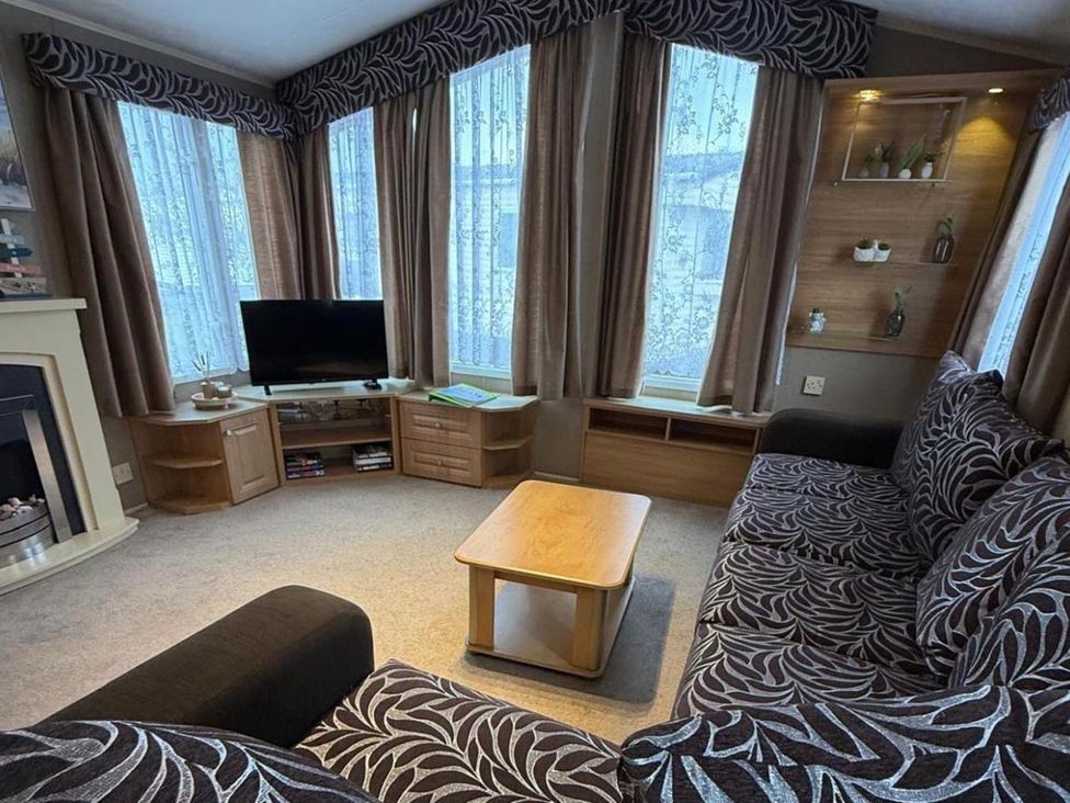 A living room with a television and a sofa at 2-Bed Caravan, Sleeps 6 w/ Parking, No Pass Needed