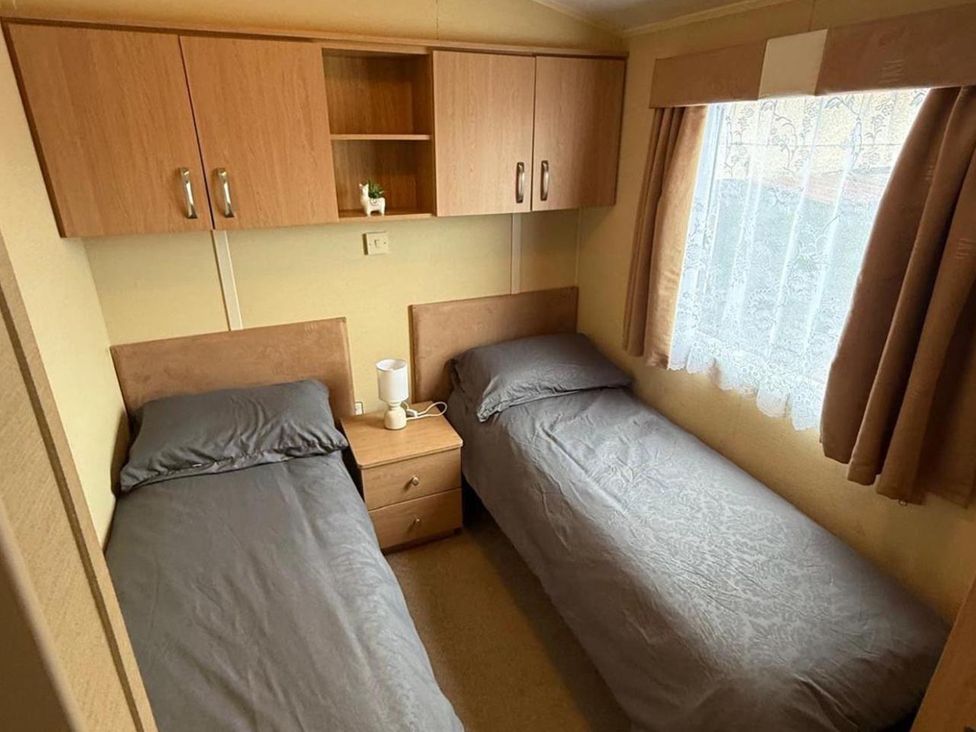 A bedroom with two beds and a nightstand at 2-Bed Caravan, Sleeps 6 w/ Parking, No Pass Needed