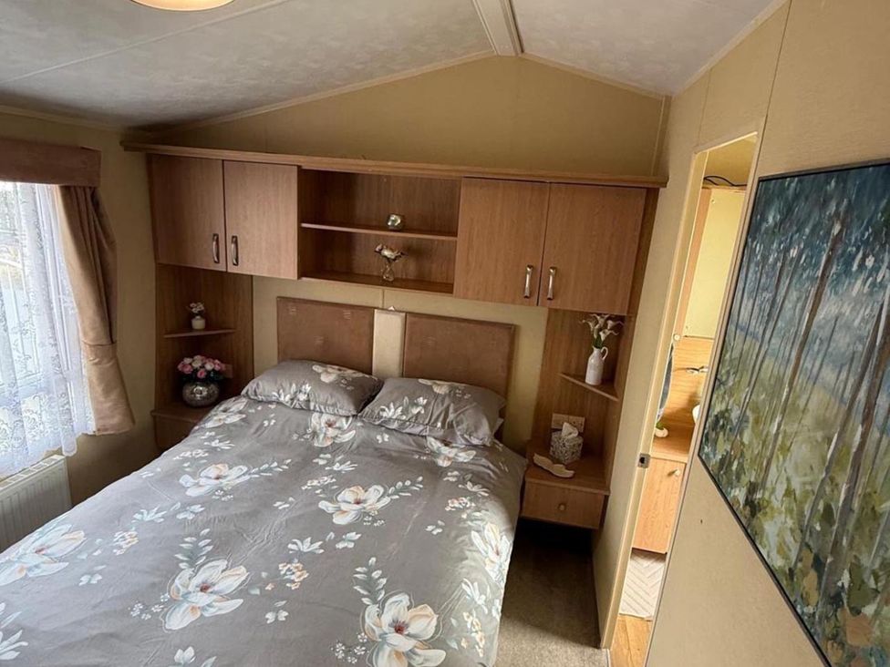 A bedroom with a bed and shelf at 2-Bed Caravan, Sleeps 6 w/ Parking, No Pass Needed